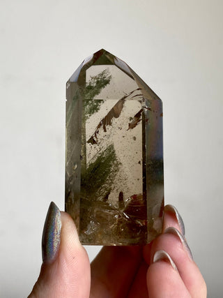 Smoky Quartz with Chlorite Phantoms - Polished Tower - Six Side Generator from Curious Muse Crystals for 38. Tagged with brown, Crystal decor, Crystal healing, genuine crystal, green, hide-notify-btn, high quality natural, Lemurian Quartz, Lemurian seed, mineral collection, natural mineral, quartz, reiki healing, smoky quartz, tower
