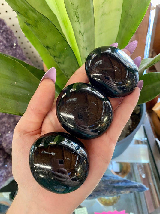 Black Tourmaline Polished Palm Stone from Curious Muse Crystals for 22. Tagged with black palm stone, black Tourmaline, Brazilian mineral, genuine crystal, grounding stone, mental stress, natural mineral, palmstone, pocket crystal, protection crystal, reiki crystal, shadow work, tourmaline