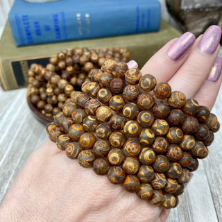 Tibetan Agate (dzi beads) 8mm Round Bead Crystal Bracelet from Curious Muse Crystals for 10. Tagged with 8mm beads, agate, bracelet, brown, crystal jewelry, gemstone bead, gemstone jewelry, healing jewelry, tibetan agate